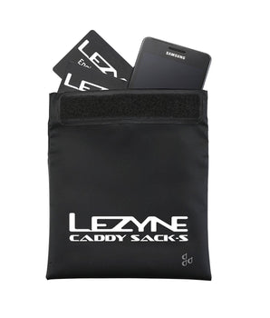 A photo of the Lezyne Caddy Sack, opened. it has "Lezyne Caddy Sack" printed at the bottom, and shows a phone and a few cards stored inside the pouch. The pouch has a velcro closure.